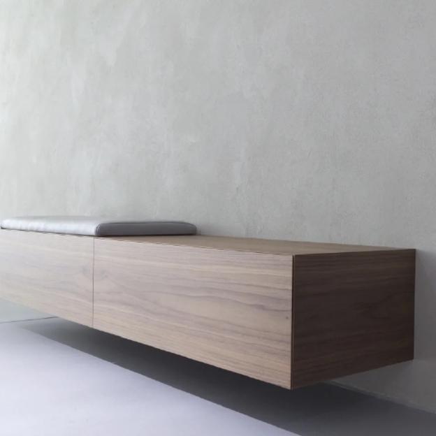 Moderne Holzbank Wandmontage Schwebende Holzbank mit grauem Sitzpolster, minimalistisch an Wand montiert.