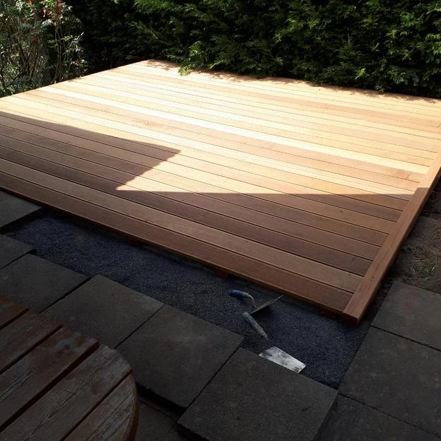 Holzterrasse Bau Außenbereich Neu gebaute Holzterrasse mit sauber verlegten Dielen und angrenzender Steinfläche.
