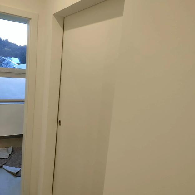 Weiße Schiebetür Innenraum Dezente weiße Schiebetür in moderner Wand eingelassen, platzsparend im Innenbereich.