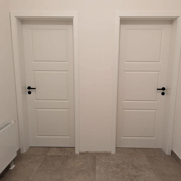 Doppel Türen Weiß Modern Zwei identische weiße Zimmertüren mit Kassettenoptik und schwarzen Türgriffen nebeneinander.