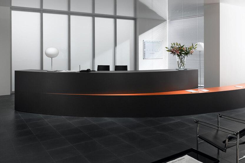 Hotelrezeption mit schwarzem Einrichtungsstil Hotelrezeption mit schwarz lackierter Empfangstheke und orangenem Kontrast