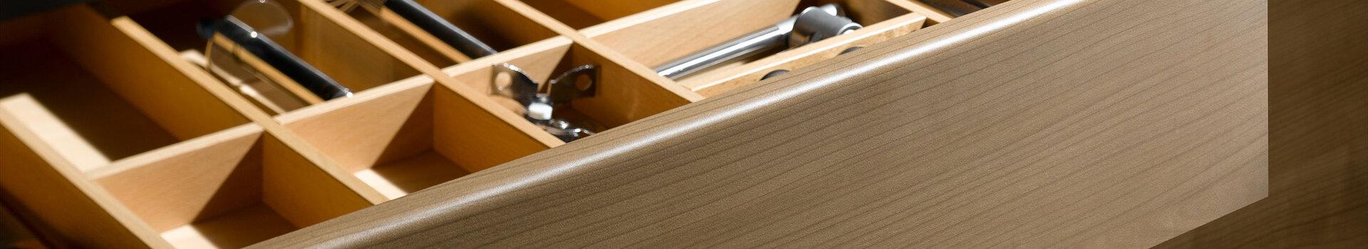 Detailaufnahme einer Besteckschublade aus Massivholz Detailaufnahme einer Besteckschublade aus hellem Massivholz
