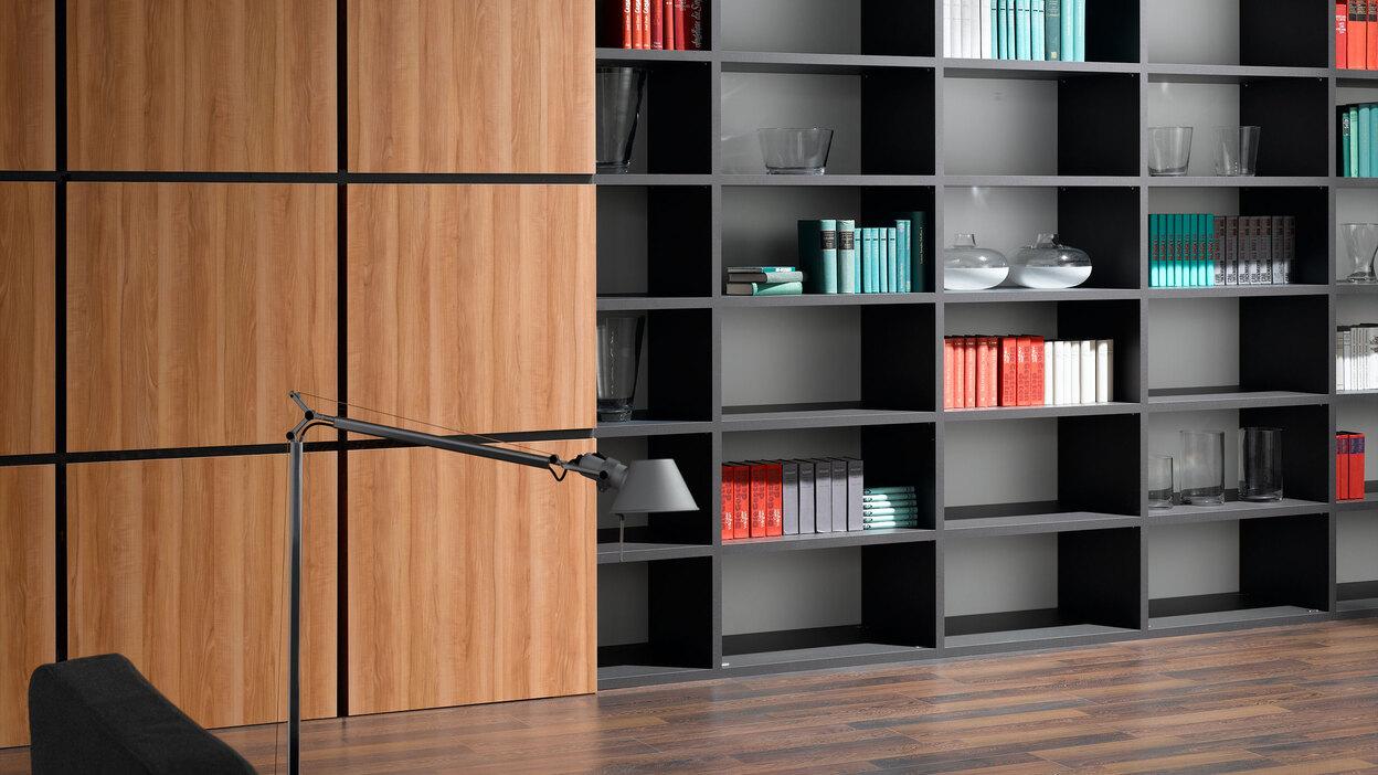 Detailaufnahme einer Regal-Schrank Kombination Detailaufnahme eines schwarz lackierten Bücherregals in Kombination mit quadratischen Holztüren für geschlossene Regalseite.