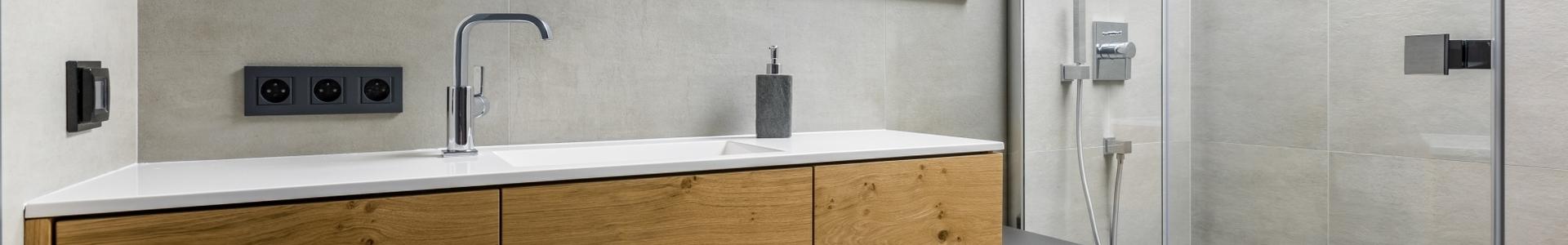Asymmetrischer Waschtisch mit Echtholz und Lackierung Asymmetrischer Waschtisch mit Schubläden in Echtholz und schwarzer Lackierung auf weiterem schmalen Unterschrank.