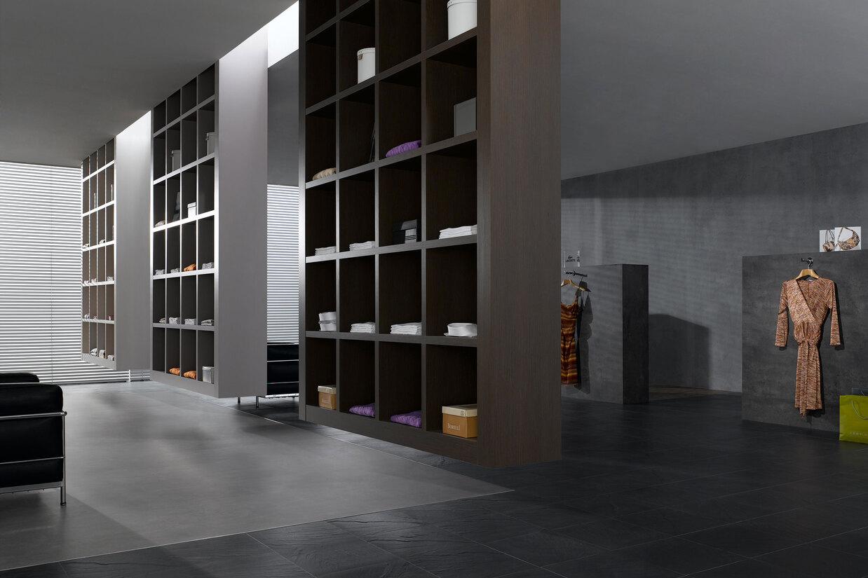 Impression eines Regalsystems in einem Bekleidungsladen Impression eines geräumigen Regalsystems aus dunklem Holz in einem hochwertigen Bekleidungsladen