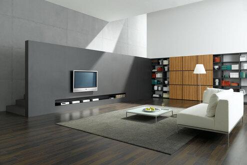 Wohnraumimpression mit Fernsehwand zur Treppe Offene Wohnraumimpression mit grauer TV-Trennwand zur Treppe und Einbauregal aus Holz und weißem Sofa