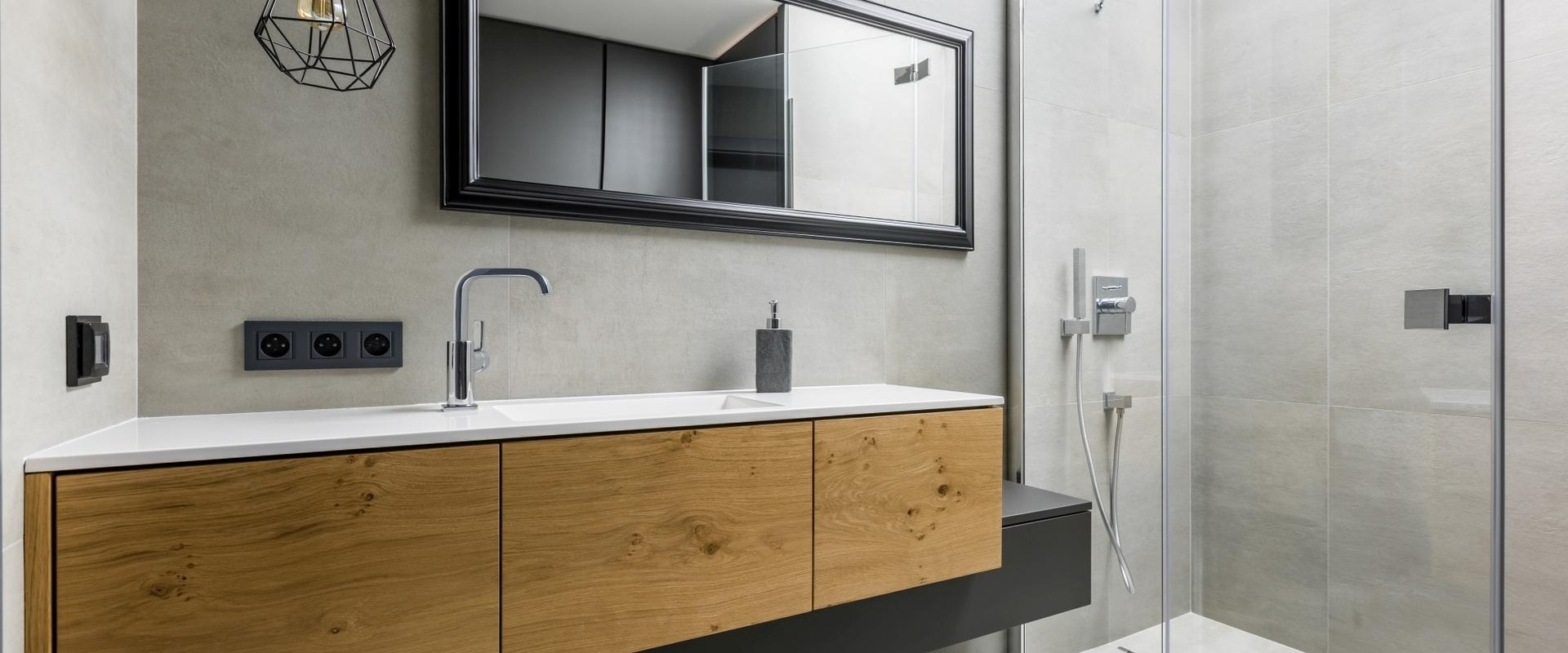 Asymmetrischer Waschtisch mit Echtholz und Lackierung Asymmetrischer Waschtisch mit Schubläden in Echtholz und schwarzer Lackierung auf weiterem schmalen Unterschrank.